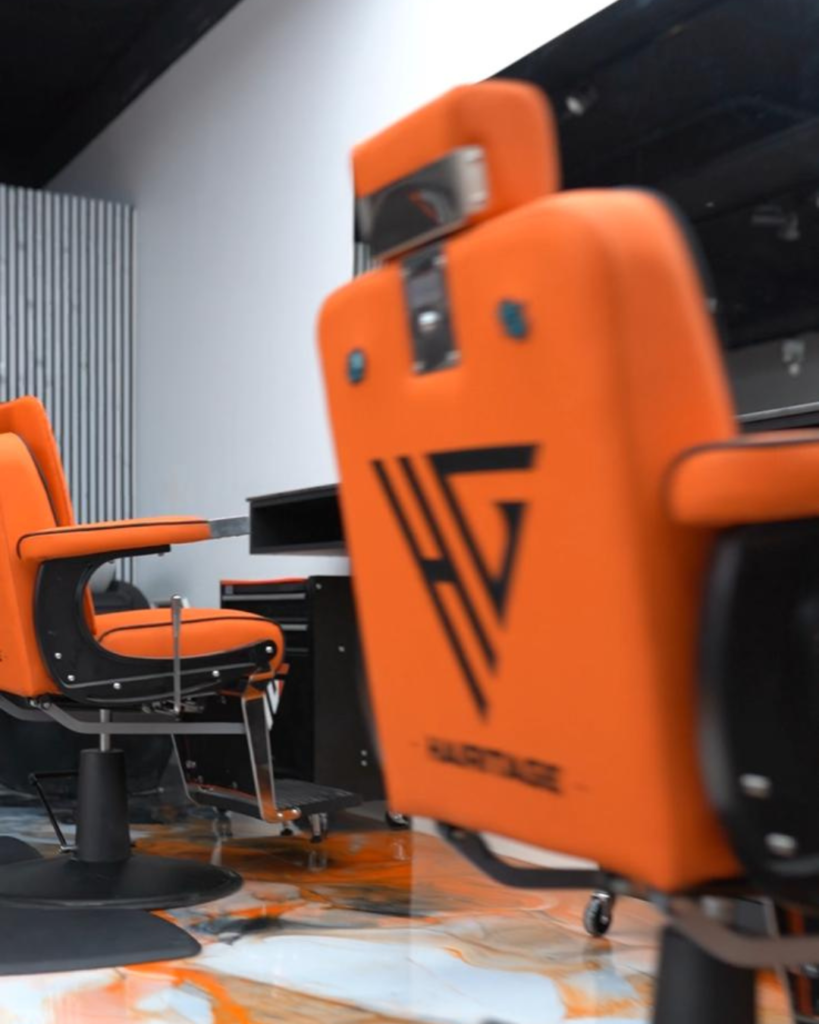 Fauteuils de barbier orange au logo Hairitage