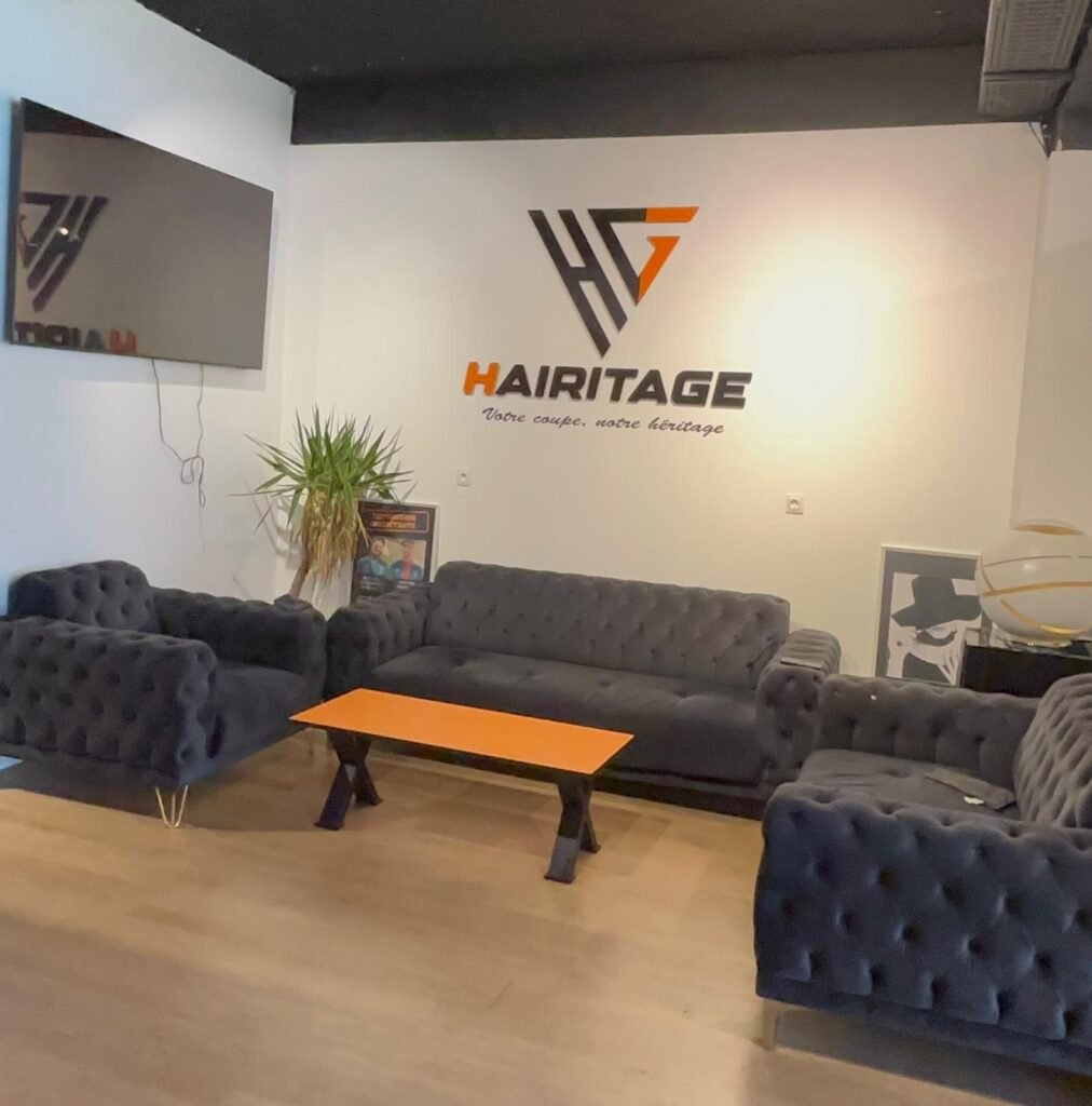 Espace d'attente Hairitage avec canapés et logo au mur