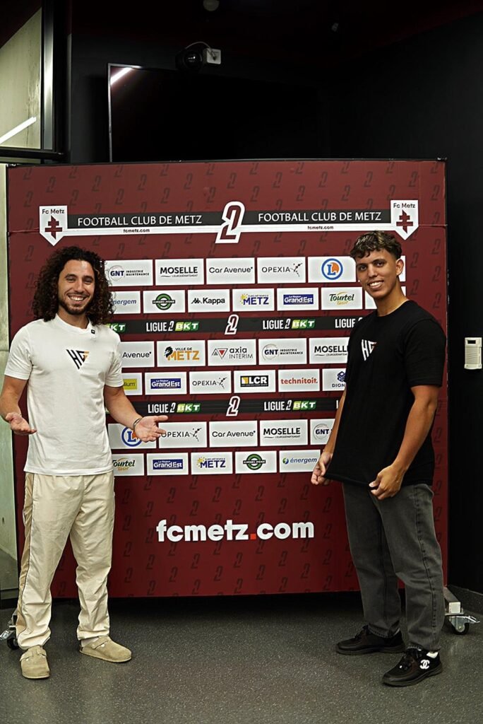Les fondateurs de Hairitage devant le mur des partenaires du FC Metz